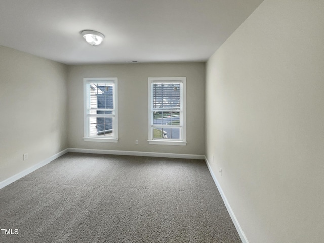 carpeted spare room featuring baseboards