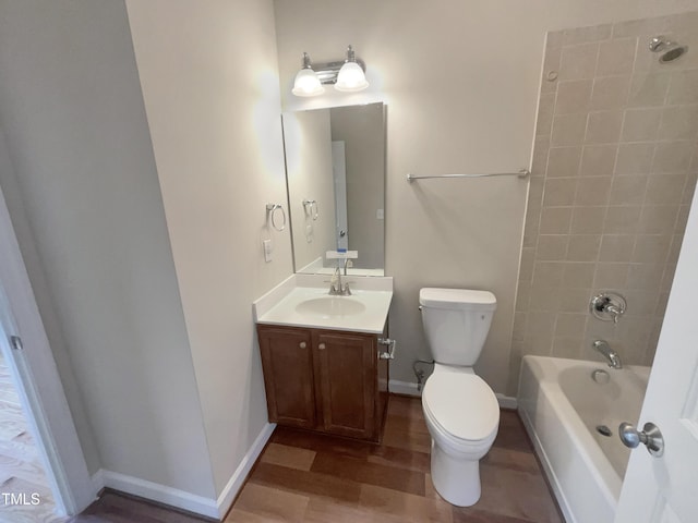 full bathroom with baseboards, toilet, bathing tub / shower combination, wood finished floors, and vanity