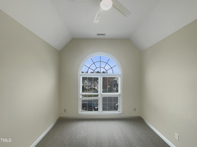 spare room with lofted ceiling, baseboards, visible vents, and carpet floors