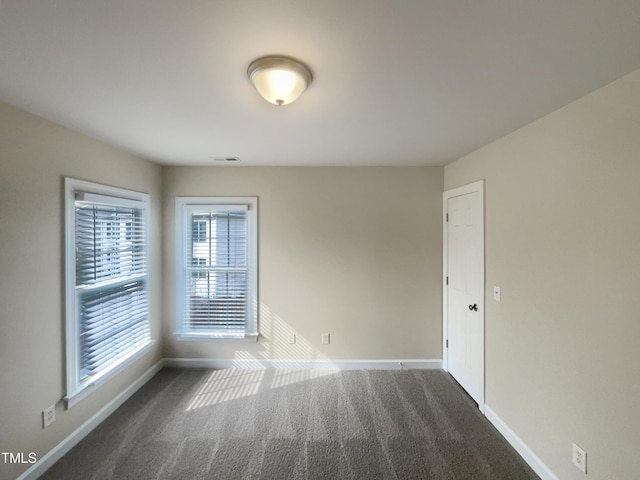 unfurnished room with visible vents, carpet flooring, and baseboards