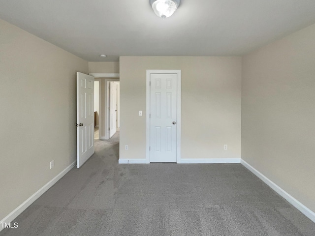 unfurnished bedroom featuring carpet flooring and baseboards