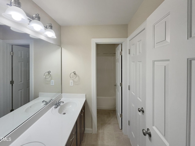 bathroom with a sink, double vanity, and tile patterned flooring