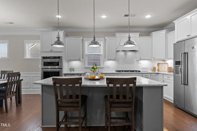 kitchen featuring crown molding, a kitchen island, dark wood-type flooring, and stainless steel appliances