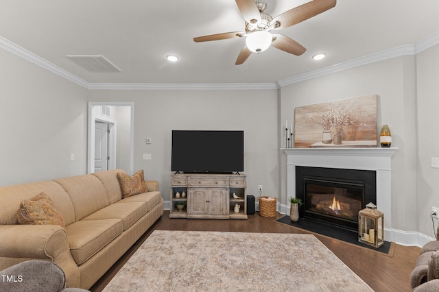 living room with visible vents, ornamental molding, a ceiling fan, and dark wood-style flooring