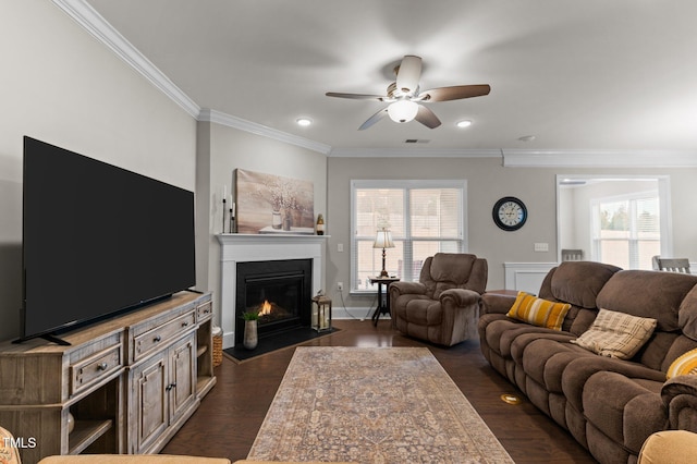 living room featuring a wealth of natural light, visible vents, dark wood-style floors, and a ceiling fan