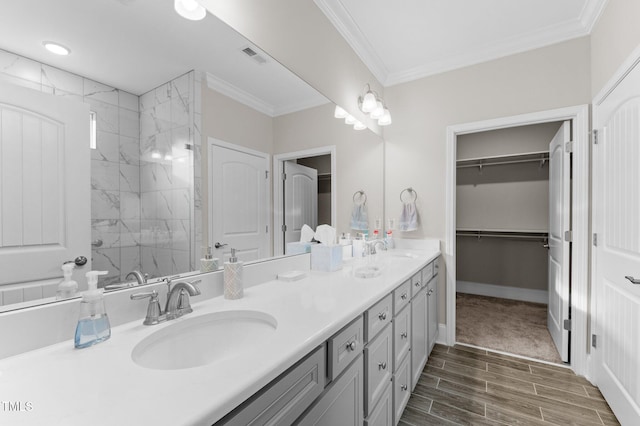 bathroom with wood tiled floor, ornamental molding, and a sink