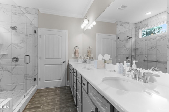 full bathroom with visible vents, a marble finish shower, double vanity, a sink, and crown molding