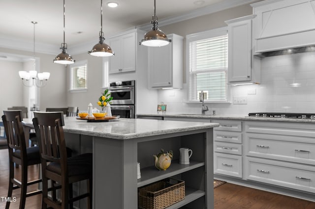 kitchen with custom range hood, open shelves, a center island, stovetop, and crown molding