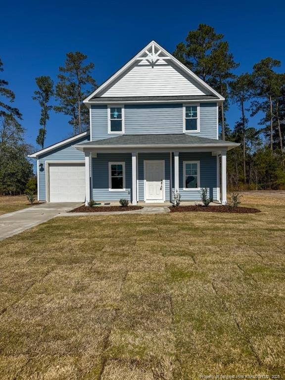 view of front of home with a front yard, concrete driveway, covered porch, and a garage