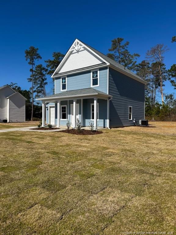 view of front of home with a front lawn, cooling unit, and a porch