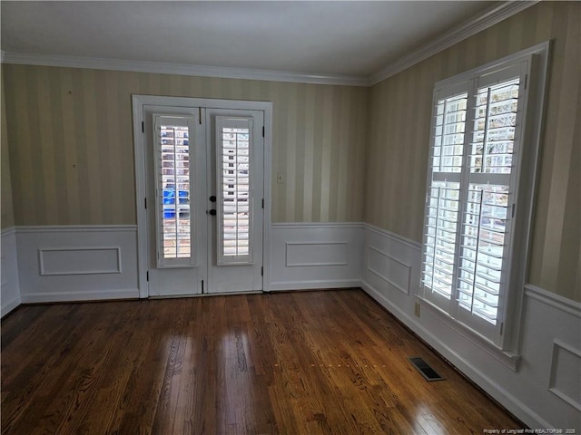 entrance foyer featuring wallpapered walls, dark wood-type flooring, visible vents, and wainscoting