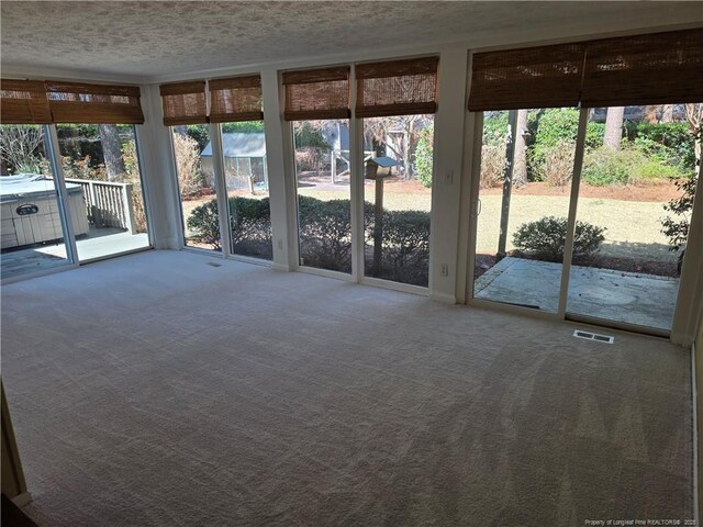 unfurnished sunroom featuring visible vents