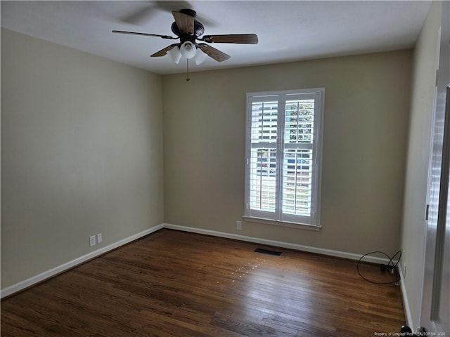 spare room with plenty of natural light, wood finished floors, visible vents, and baseboards