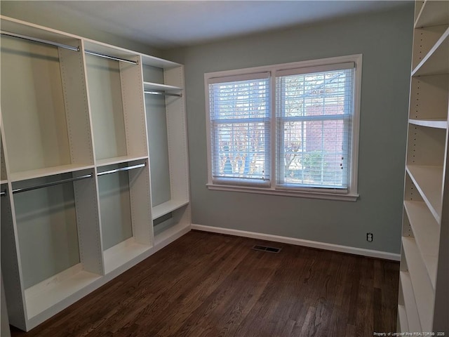 spacious closet featuring dark wood-style floors and visible vents