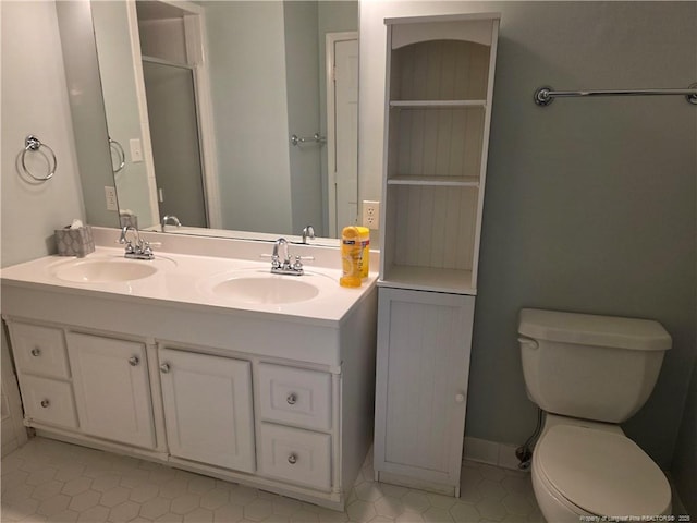 full bathroom with double vanity, toilet, and a sink