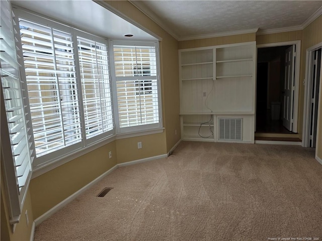 unfurnished living room featuring crown molding, carpet flooring, baseboards, and visible vents