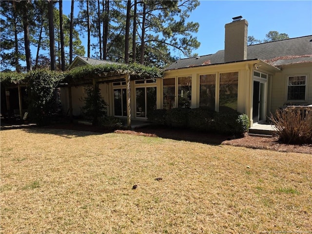 back of property featuring a yard and a chimney