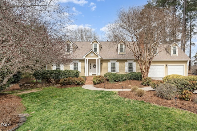 cape cod home featuring a garage, roof with shingles, and a front yard