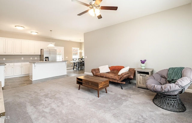 living room with light colored carpet, baseboards, and ceiling fan