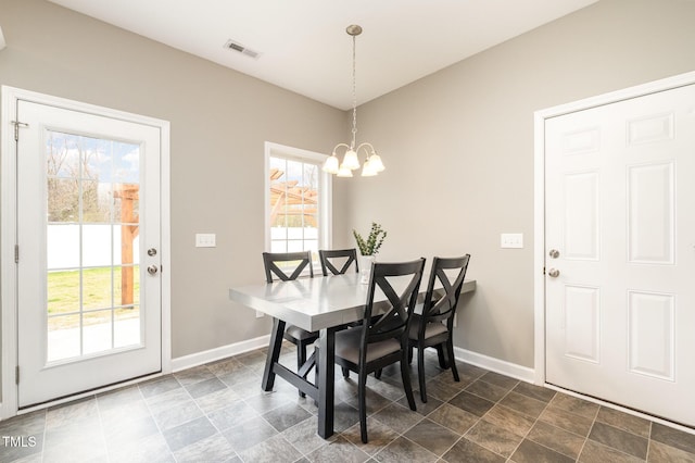 dining room featuring an inviting chandelier, a healthy amount of sunlight, visible vents, and baseboards