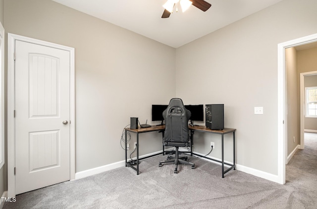 carpeted office featuring baseboards and ceiling fan