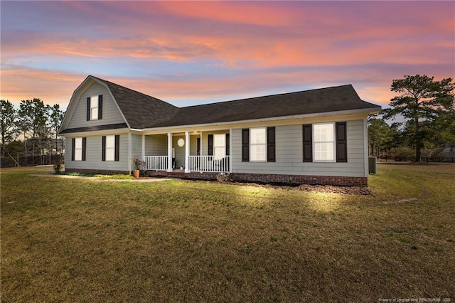 view of front facade featuring central AC unit, a porch, and a front yard