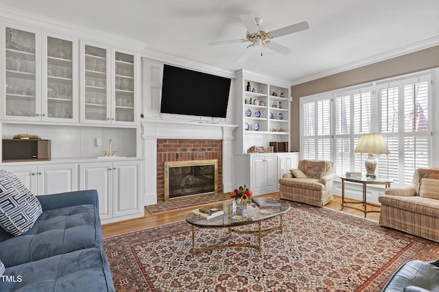511 Windstream Way, Cary, NC 27518 - living area with wood finished floors, a ceiling fan, a fireplace, ornamental molding, and built in shelves