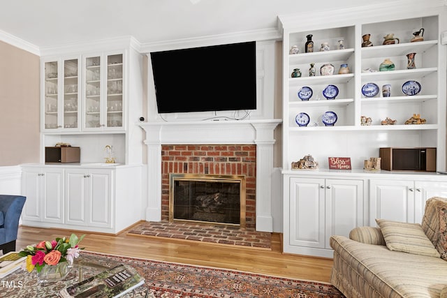 511 Windstream Way, Cary, NC 27518 - living room with light wood finished floors, a brick fireplace, crown molding, and built in features