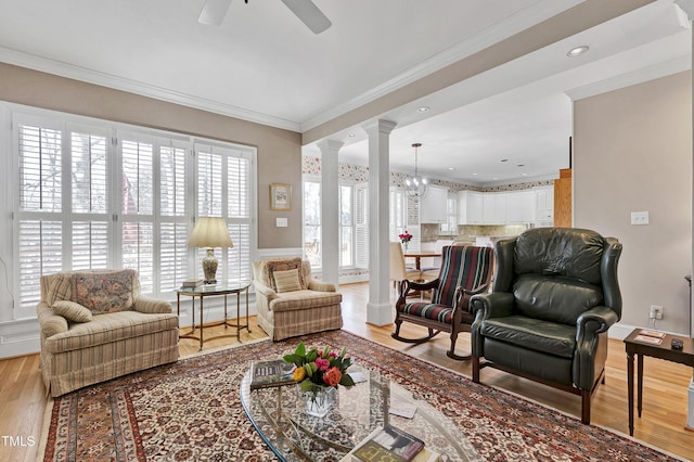 511 Windstream Way, Cary, NC 27518 - living room with decorative columns, light wood finished floors, ceiling fan, ornamental molding, and a chandelier