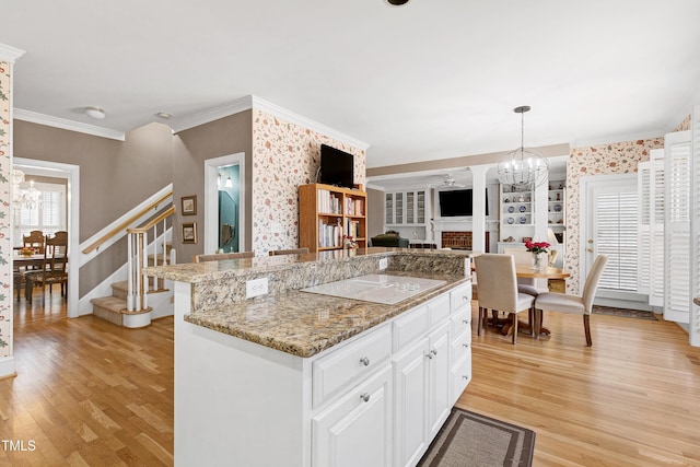 511 Windstream Way, Cary, NC 27518 - kitchen featuring a chandelier, light wood-style flooring, ornamental molding, white cabinetry, and light stone counters