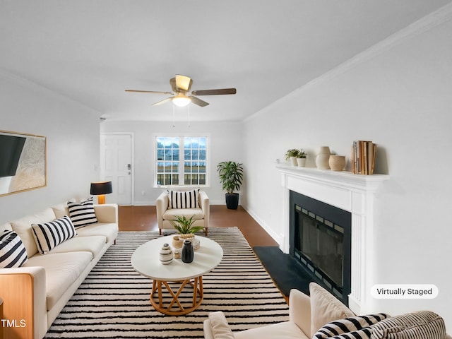 living room with a fireplace with flush hearth, baseboards, crown molding, and a ceiling fan