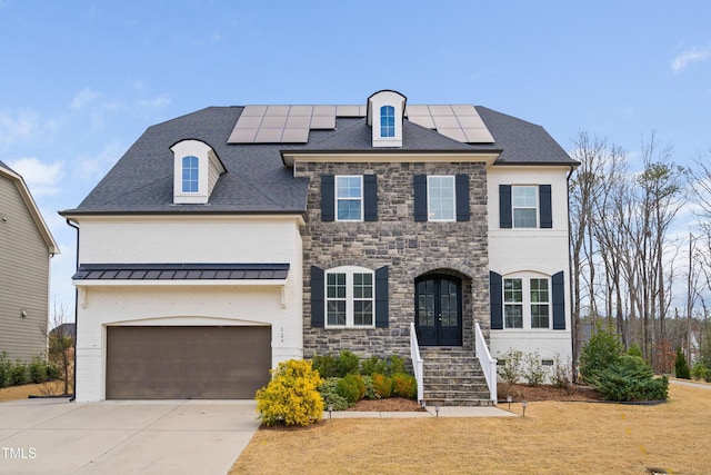 french provincial home featuring solar panels, concrete driveway, french doors, a garage, and brick siding