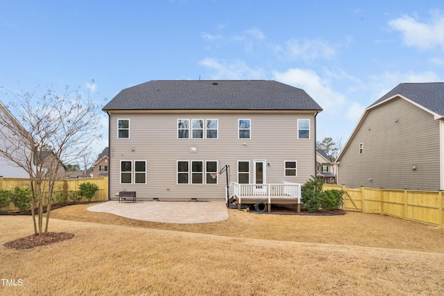 rear view of house with a deck, a patio, and a fenced backyard