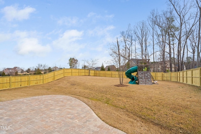 view of yard with a patio area, a playground, and a fenced backyard