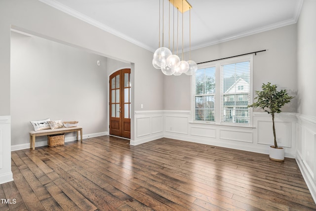 unfurnished dining area with a wainscoted wall, hardwood / wood-style flooring, arched walkways, and ornamental molding