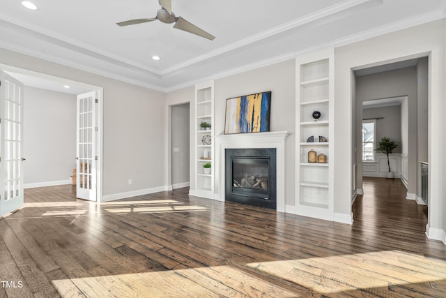 unfurnished living room featuring a high end fireplace, ornamental molding, french doors, and hardwood / wood-style flooring