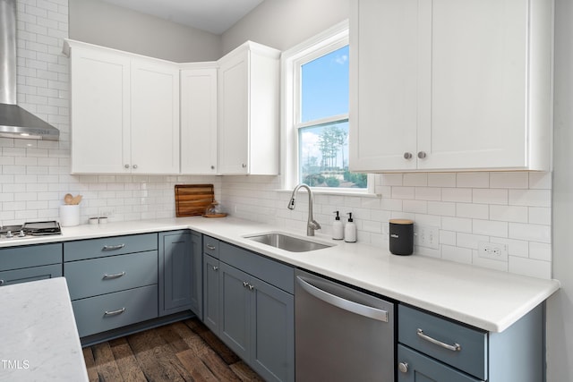 kitchen with dark wood-style floors, a sink, stainless steel appliances, wall chimney exhaust hood, and backsplash