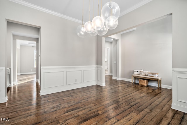 unfurnished dining area with dark wood-style floors, wainscoting, and ornamental molding