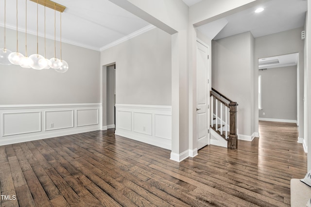 spare room with stairway, ornamental molding, a wainscoted wall, and hardwood / wood-style floors