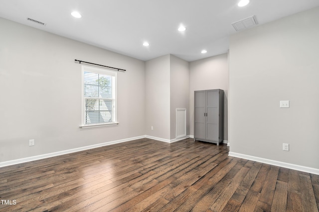 spare room with recessed lighting, dark wood-style floors, and visible vents