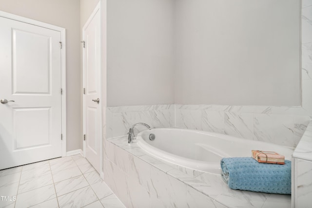 full bath with a garden tub and marble finish floor