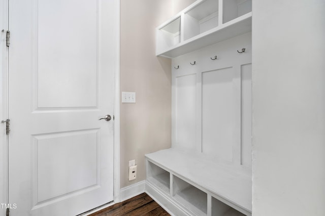 mudroom with dark wood finished floors and baseboards