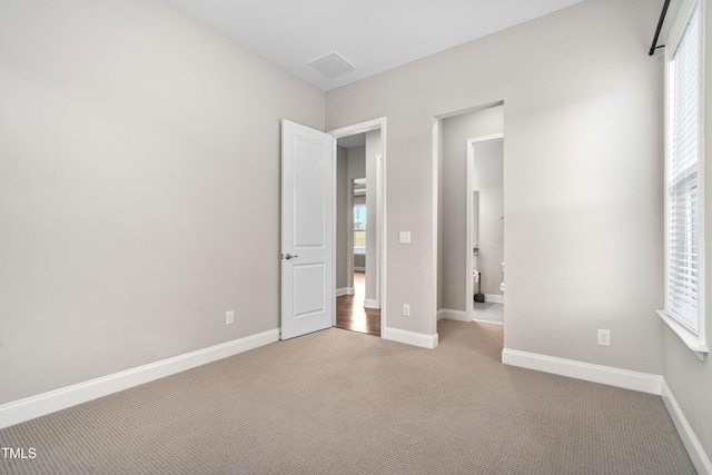 unfurnished bedroom with visible vents, baseboards, and carpet