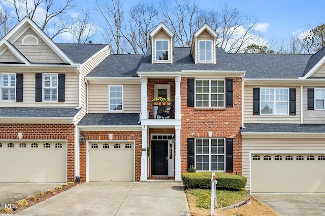 multi unit property with brick siding, concrete driveway, and a garage