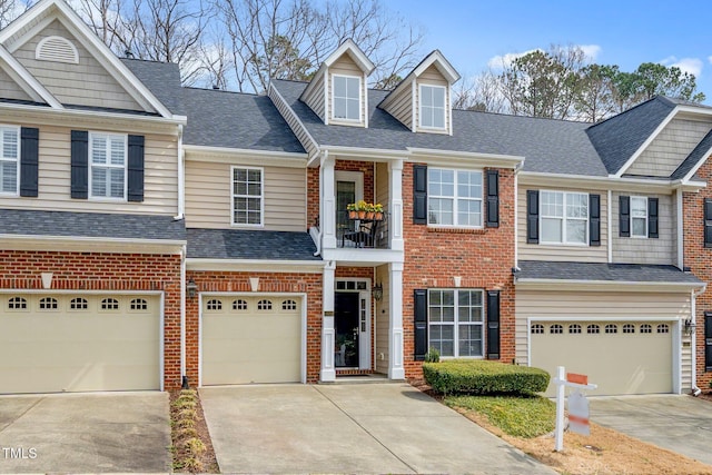 multi unit property featuring a garage, brick siding, driveway, and a shingled roof