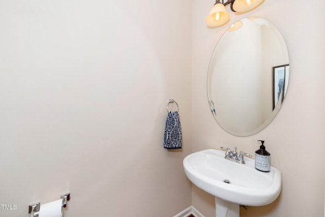 bathroom with a sink and baseboards