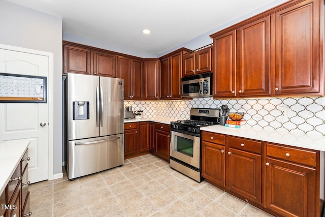 kitchen with recessed lighting, stainless steel appliances, tasteful backsplash, and light countertops