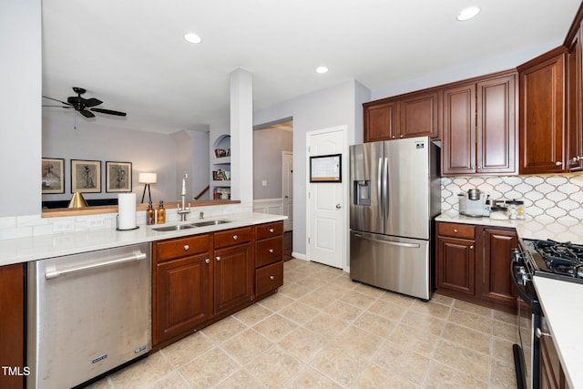 kitchen featuring a sink, ceiling fan, light countertops, decorative backsplash, and stainless steel appliances