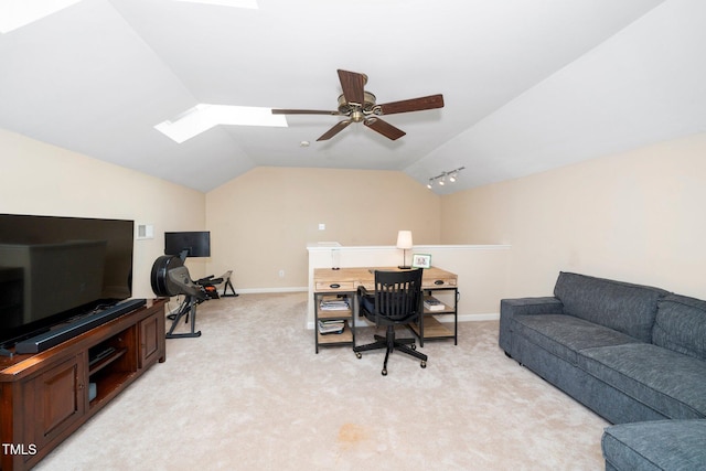 office area with baseboards, vaulted ceiling with skylight, light carpet, and a ceiling fan