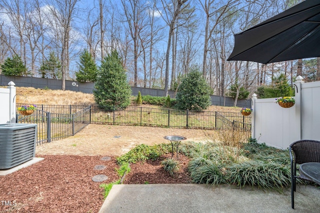 view of yard with a fenced backyard and central AC